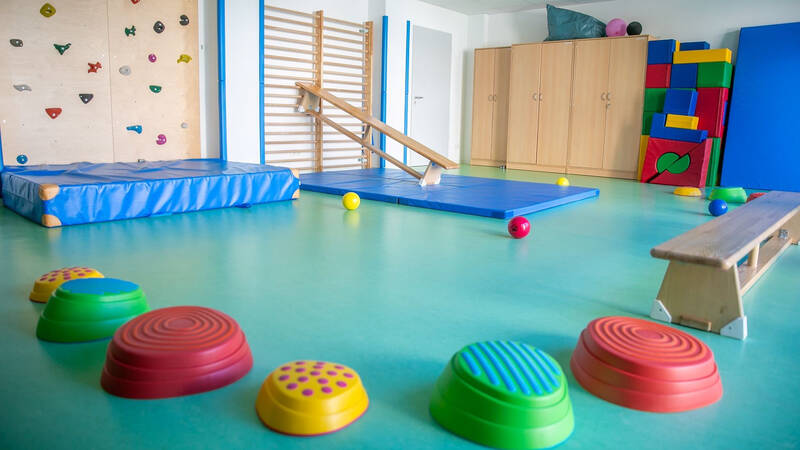 Bewegungsraum in einem Kindergarten mit Kletterwand, Sprossenwand, Tutnmatte und Balanciersteinen